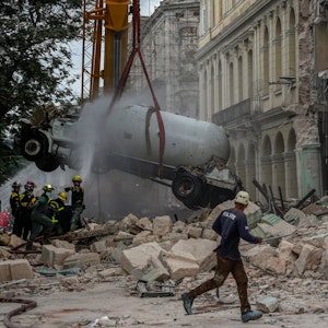06.05.2022, Kuba, Havanna: Feuerwehrleute besprühen einen Tankwagen mit Wasser, um ihn zu kühlen, während sie ihn vom Ort einer tödlichen Explosion entfernen, die das Fünf-Sterne-Hotel Saratoga in Havanna, Kuba, zerstört hat.