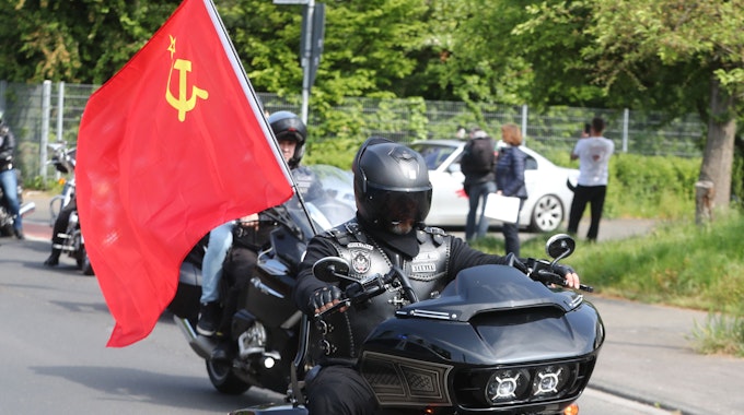 Motorradfahrer fährt mit sowjetischer Flagge durch Köln..