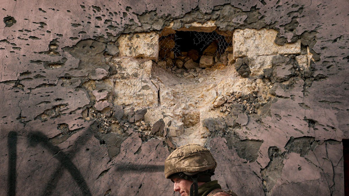 Ein ukrainischer Soldat geht an einem Gebäude vorbei, das von einer großkalibrigen Mörsergranate im Frontdorf Krymske in der Region Luhansk in der Ostukraine getroffen wurde.
