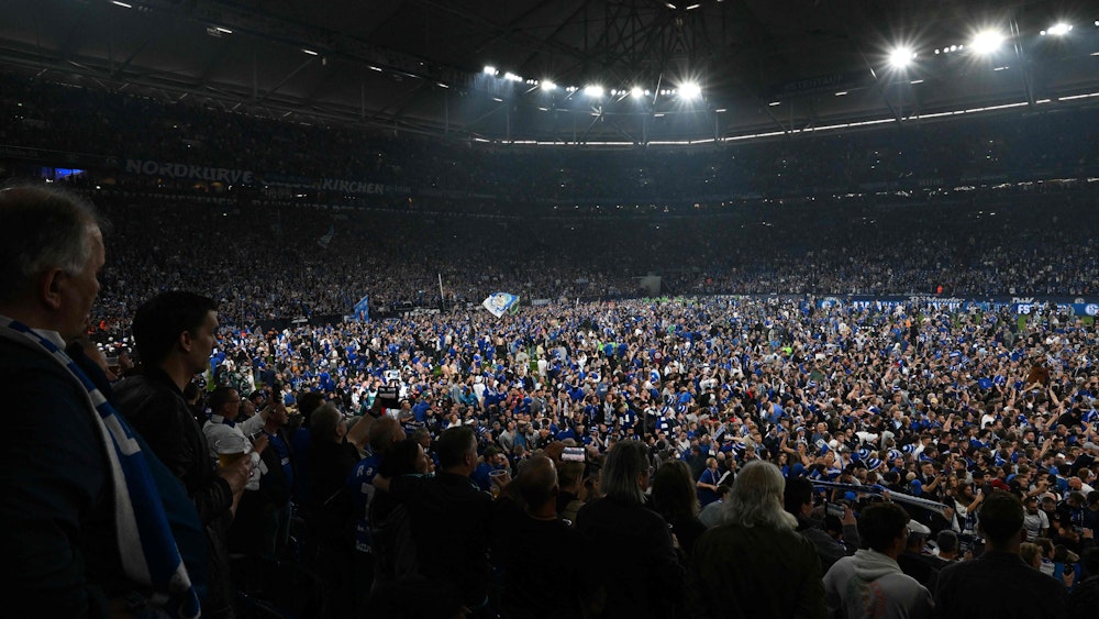 Mehrere Tausend Fans von Schalke 04 stürmen bei den Aufstiegs-Feierlichkeiten den Rasen der Veltins-Arena.