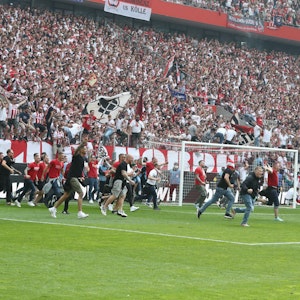 Die Fans des 1. FC Köln stürmen den Platz.