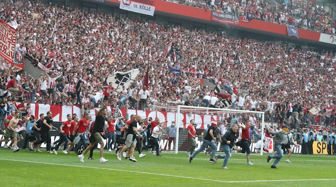 Die Fans des 1. FC Köln stürmen den Platz.