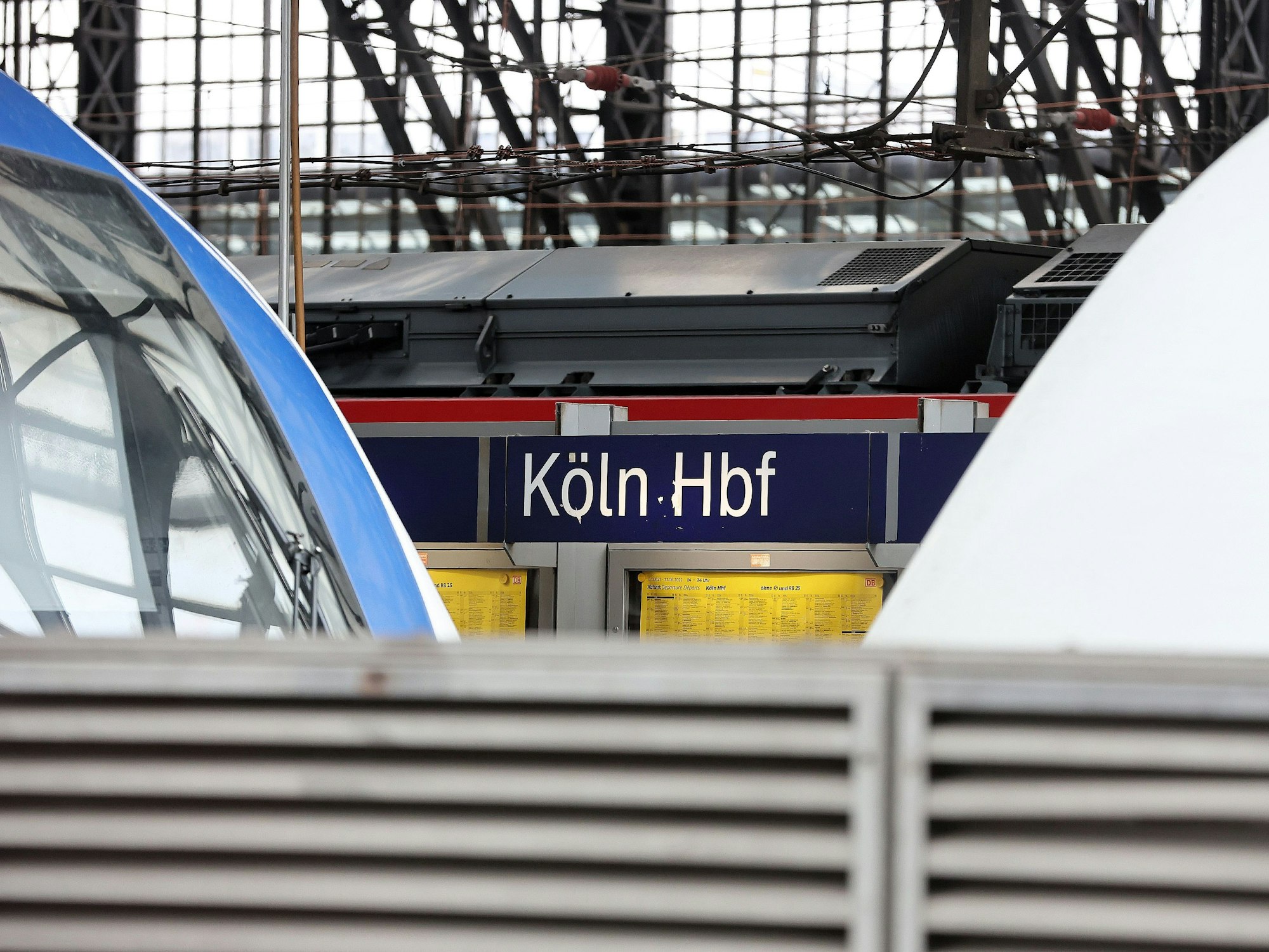 Schild am Hauptbahnhof Köln, davor Züge.