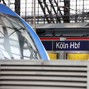 Schild am Hauptbahnhof Köln, davor Züge.