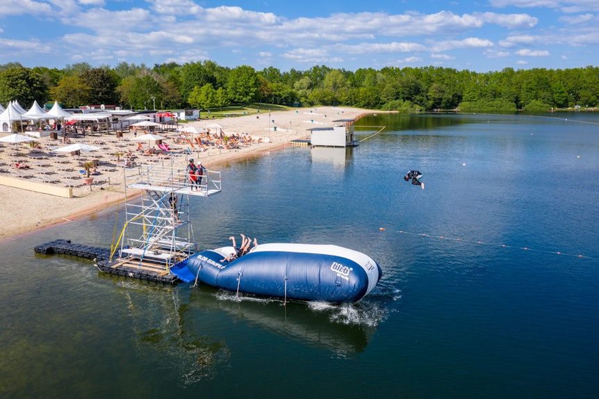 Ein großes Luftkissen („Blob“) im Otto-Maigler-See schleudert Turmspringer der Splashdiving-Gruppe „Cologne Bombs“ am 30. Mai 2021 ins Wasser.