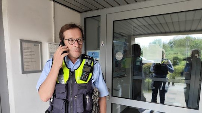Polizist Sven Bartz telefoniert in einem Hauseingang.