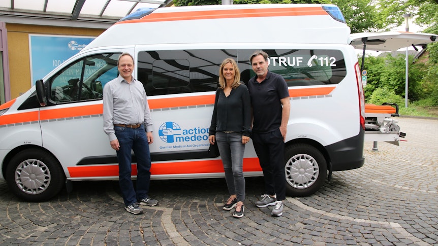 Christoph Bonsmann, Anja Funkel und Volker Struth übergeben den Krankenwagen.