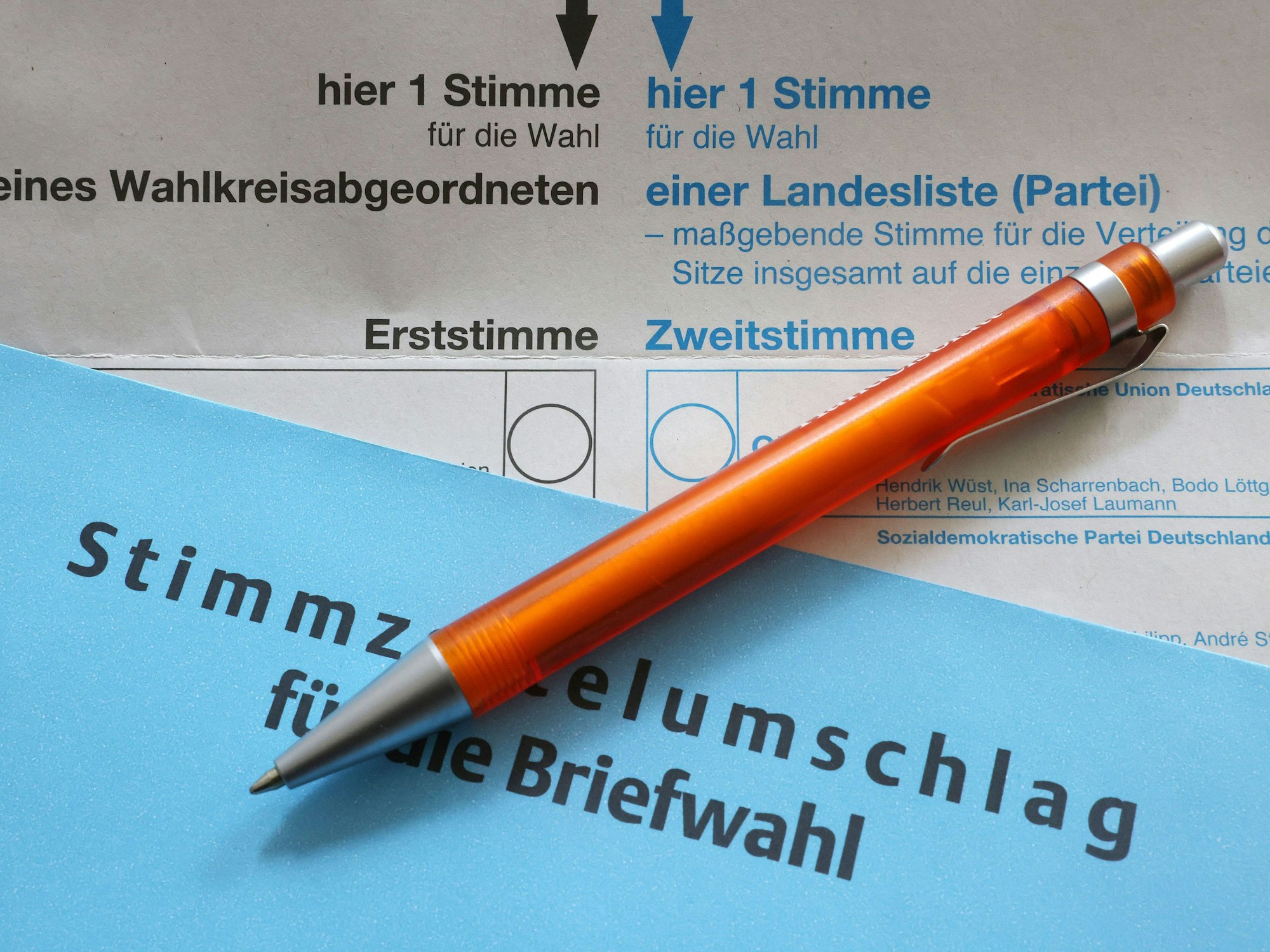 Blauer Briefwahlumschlag mit Stift und Stimmzettel für die NRW-Landtagswahl 2022. 