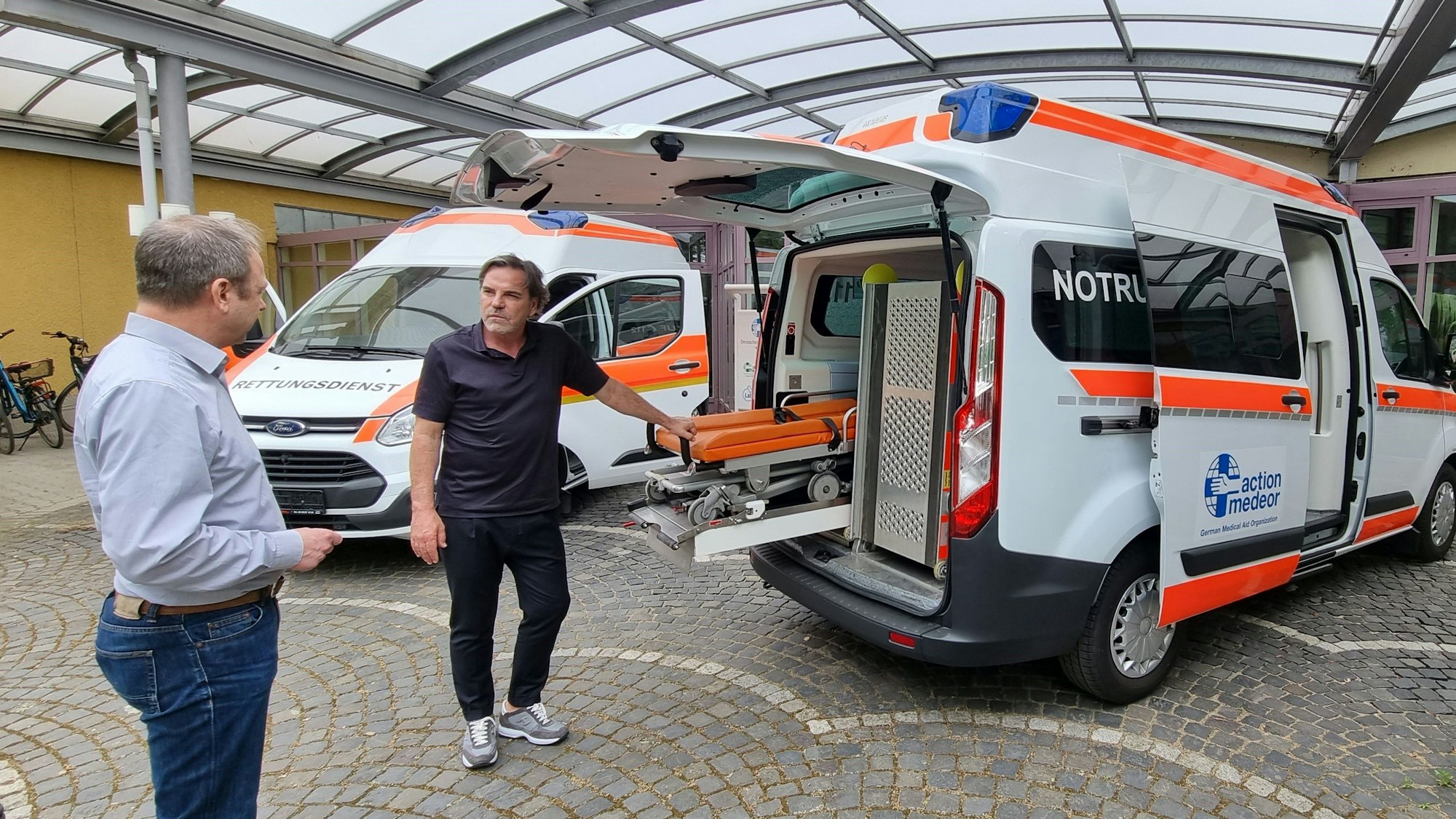 Volker Struth und Christoph Bonsmann mit dem Krankenwagen.