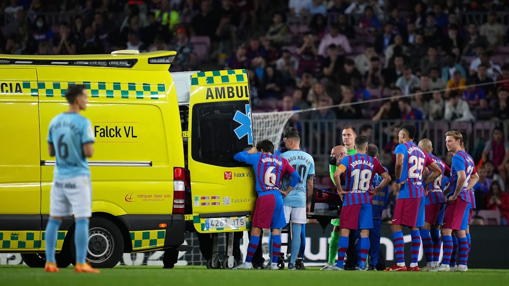 Die Spieler des FC Barcelona und von Celta Vigo haben sich geschockt neben einem Krankenwagen versammelt.