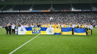 Gemeinsames Mannschaftsfoto vor dem Spiel mit dem Banner STOP WAR. Aufgenommen am 11. Mai 2022 beim Freundschaftsspiel der Ukraine und Borussia Mönchengladbach.