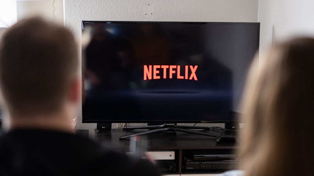 Ein Paar sitzt am 14. September 2021 vor dem Fernseher, auf dem das Netflix-Logo zu sehen ist.