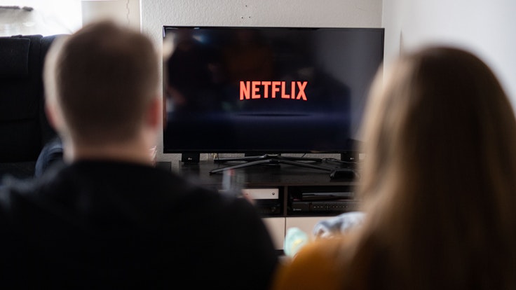 Ein Paar sitzt am 14. September 2021 vor dem Fernseher, auf dem das Netflix-Logo zu sehen ist.