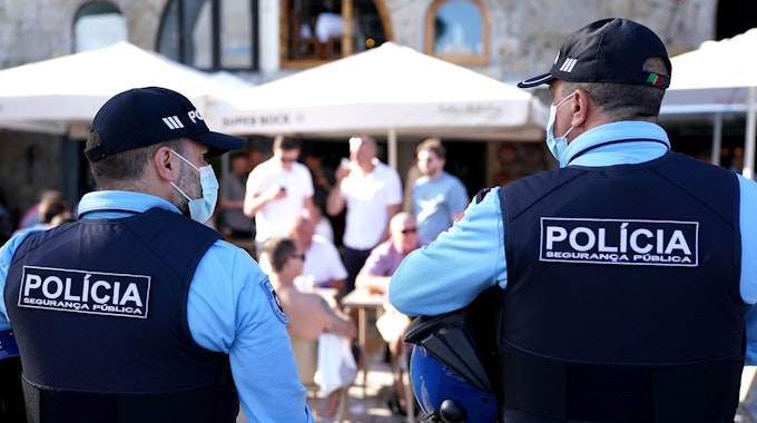 Spanische Polizisten stehen in Uniform auf einer öffentlichen Straße.