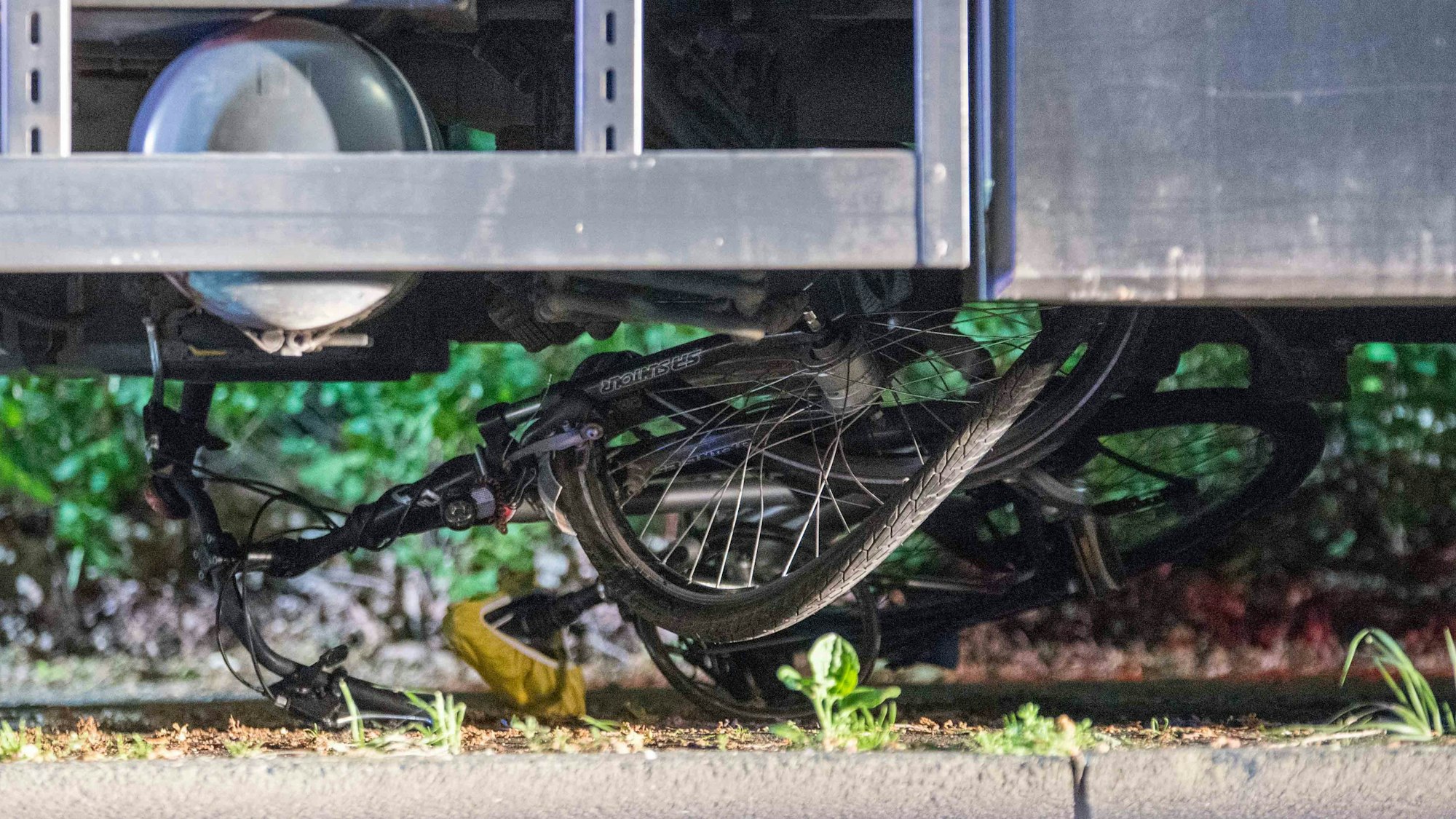 Ein Fahrrad liegt nach einem Unfall unter einem Lastwagen.