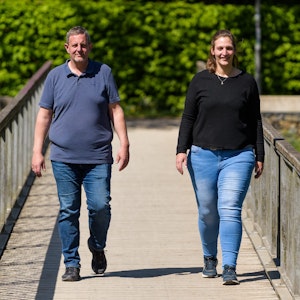 Michael Wirtz und Meike Preußner gehen zusammen auf einer Brücke entlang. Beide engagieren sich in der Adipositas-Selbsthilfe und haben in der Vergangenheit rund 160 Kilogramm auf die Waage gebracht