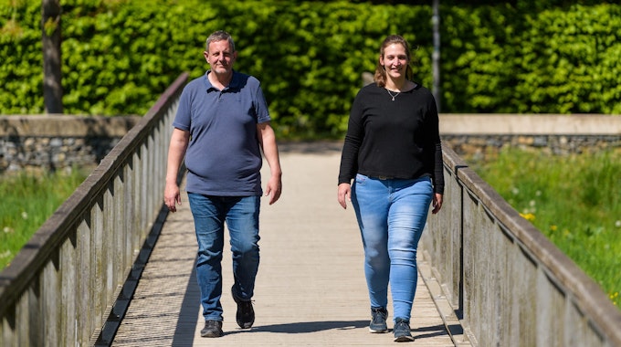 Michael Wirtz und Meike Preußner gehen zusammen auf einer Brücke entlang. Beide engagieren sich in der Adipositas-Selbsthilfe und haben in der Vergangenheit rund 160 Kilogramm auf die Waage gebracht