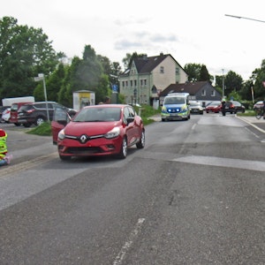 Ein roter Renault Clio steht nach einem Unfall auf der Straße – dahinter ein Polizeifahrzeug.