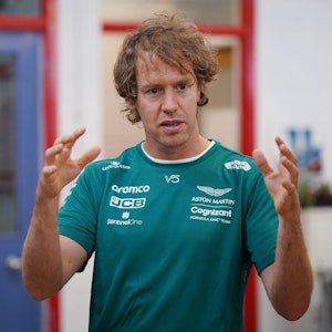 Sebastian Vettel erklärt und gestikuliert mit seinen Armen.