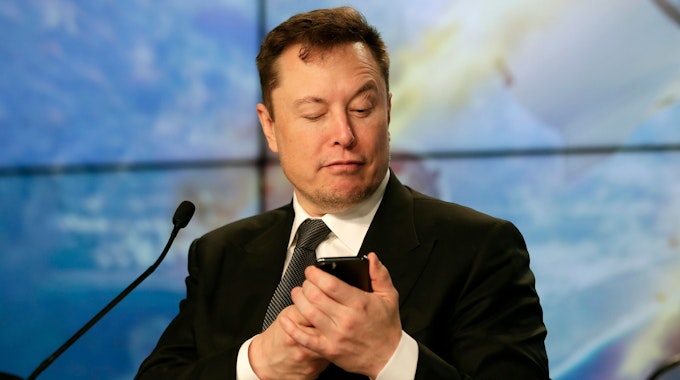 Elon Musk schaut am 19. Januar 2020 auf sein Handy.