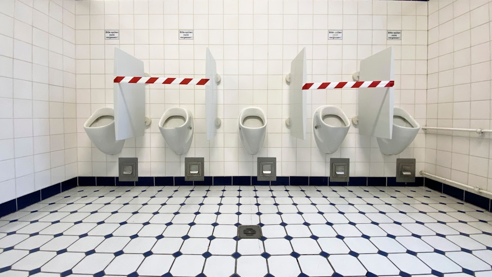Absperrband ist auf einer Herren-Toilette angebracht.