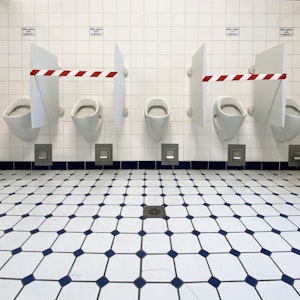 Absperrband ist auf einer Herren-Toilette angebracht.