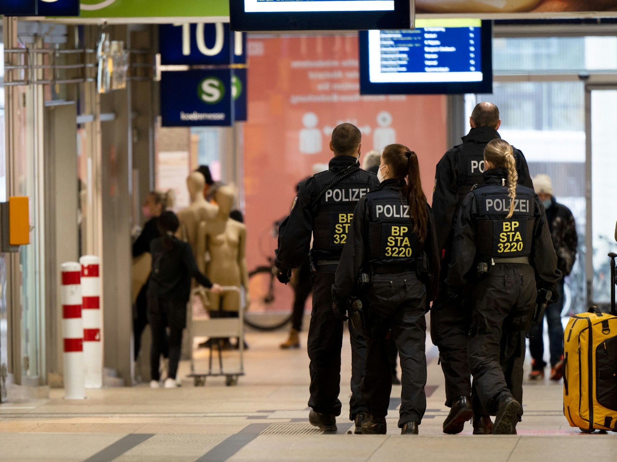 Frauen und Männer der Bundespolizei gehen durch den Hauptbahnhof in Köln.