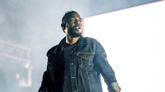 Kendrick Lamar mit Mikrofon auf einer Konzertbühne.