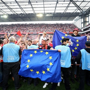 Fans feiern mit einem Platzsturm und Europa-Flaggen den Einzug des 1. FC Köln in die Europa Conference League.