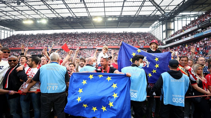 Fans feiern mit einem Platzsturm und Europa-Flaggen den Einzug des 1. FC Köln in die Europa Conference League.