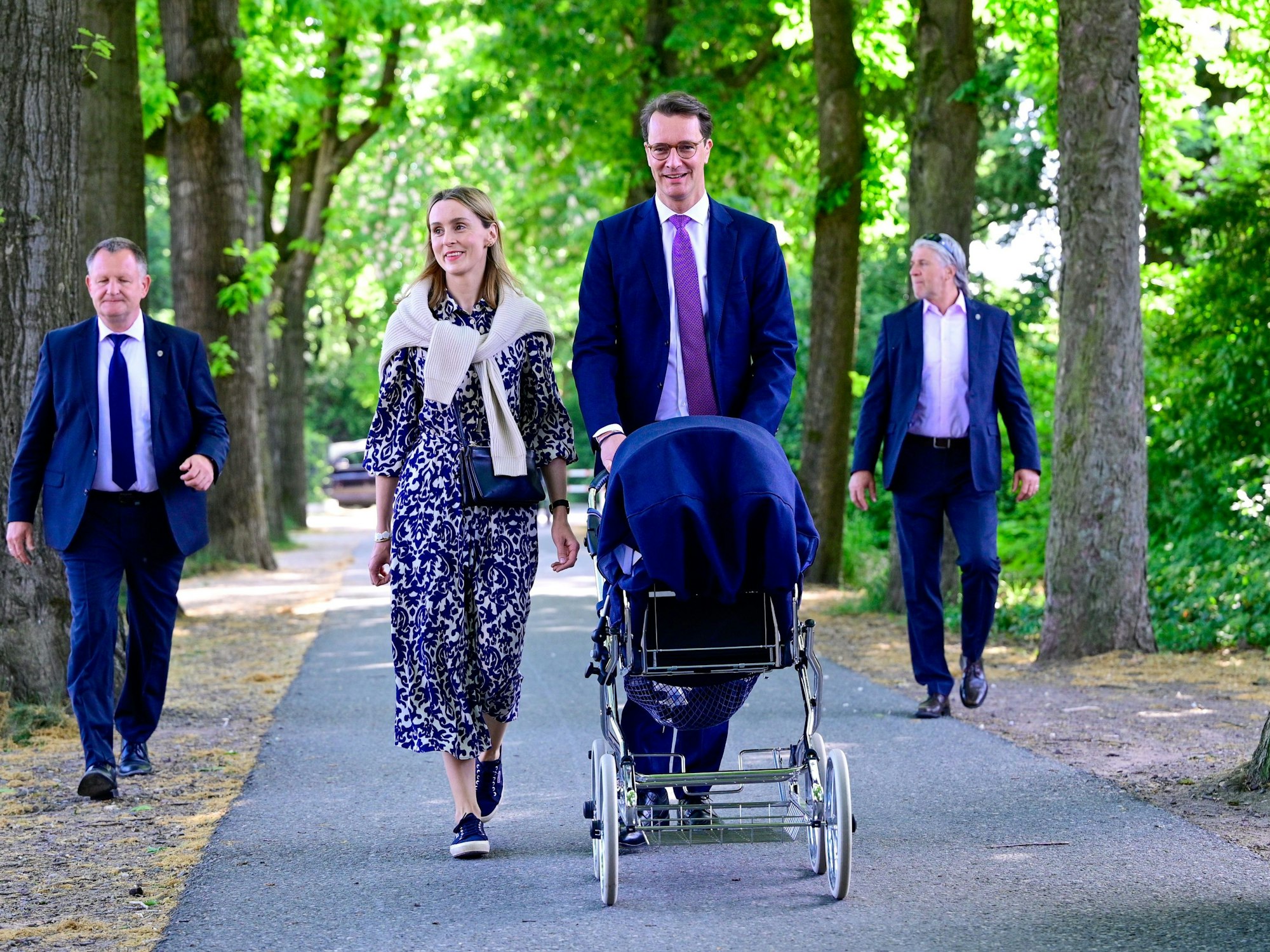 Hendrik Wüst spaziert mit seiner Familie durch einen Park.