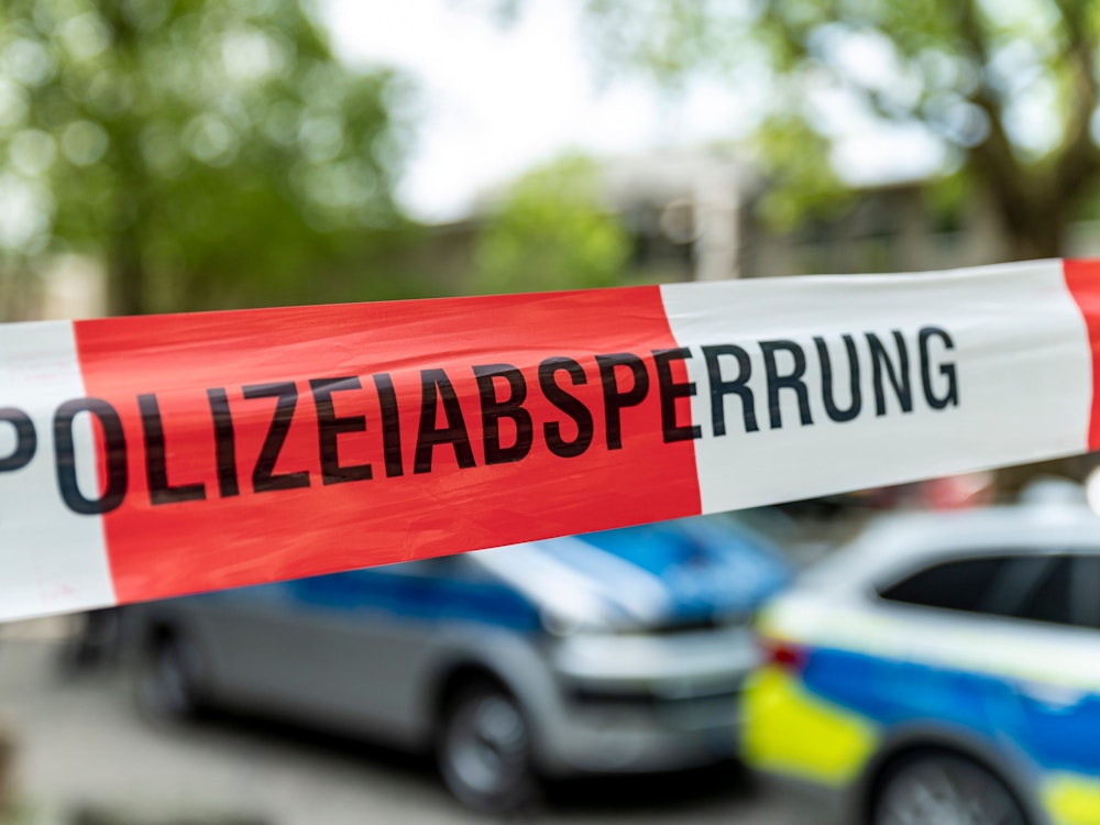 Absperrung der Kölner Polizei, dahinter Polizei-Autos.