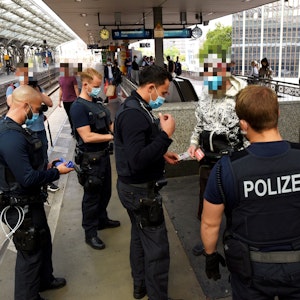 Kräfte von Polizei, Ordnungsamt und DB Sicherheit kontrollieren auf einem Bahnsteig des Kölner Hauptbahnhofs einen Mann.