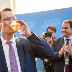 Hendrik Wüst nimmt in Düsseldorf auf seiner Wahlparty ein Schluck von einem Bier.