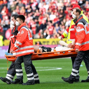 Florian Wirtz wird beim Spiel Bayer Leverkusen gegen den 1. FC Köln verletzt auf einer Trage vom Platz getragen.