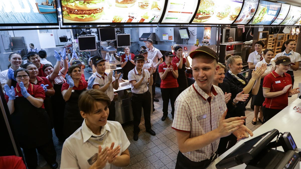 Mitarbeiter des Fast-Food-Restaurants McDonald's auf dem Puschkin-Platz in Moskau applaudieren 2014, weil ihre Filiale damals wiedereröffnet worden ist.