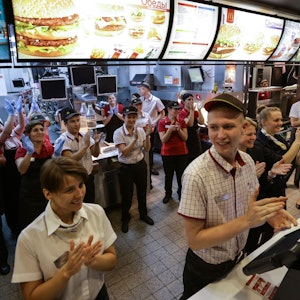 Mitarbeiter des Fast-Food-Restaurants McDonald's auf dem Puschkin-Platz in Moskau applaudieren 2014, weil ihre Filiale damals wiedereröffnet worden ist.