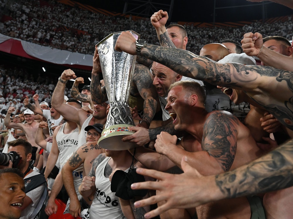 Eintracht Frankfurts Fans feiern mit dem Pokal.