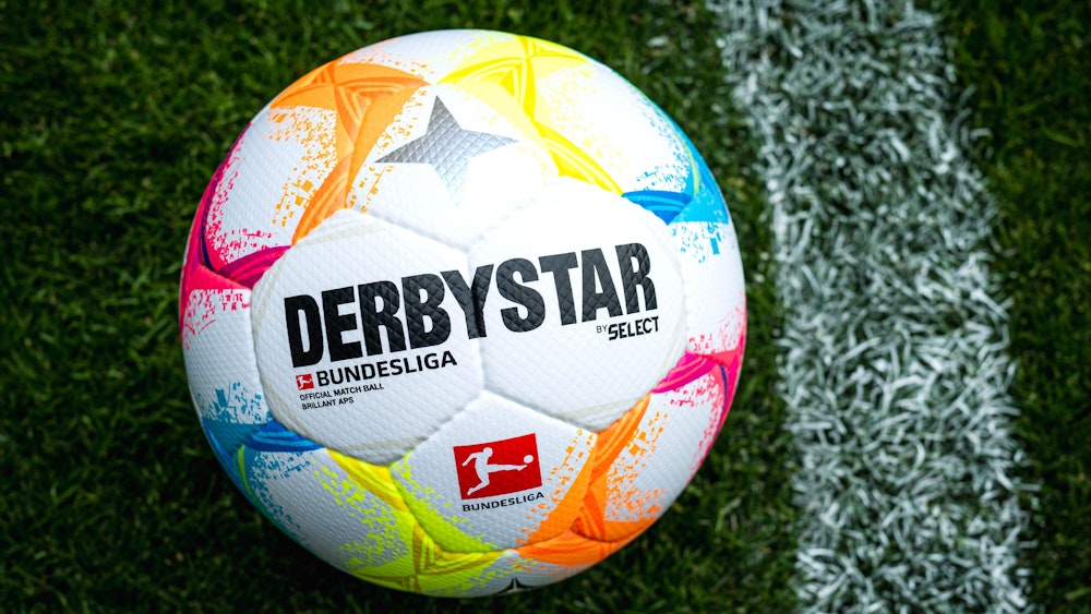 Der neue Bundesliga-Spielball mit vielen farblichen Details liegt auf Fußball-Rasen