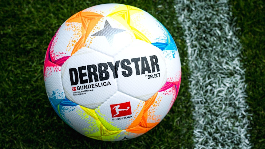 Der neue Bundesliga-Spielball mit vielen farblichen Details liegt auf Fußball-Rasen