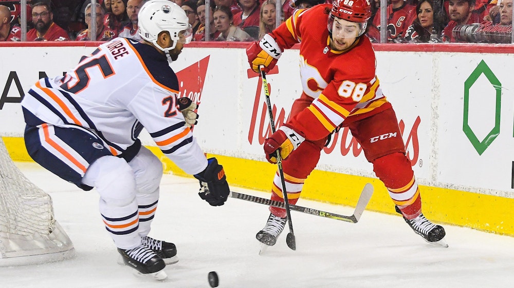 Andrew Mangiapane von den Calgary Flames kämpf mit Darnell Nurse von den Edmonton Oilers auf dem Eis um den Puck.