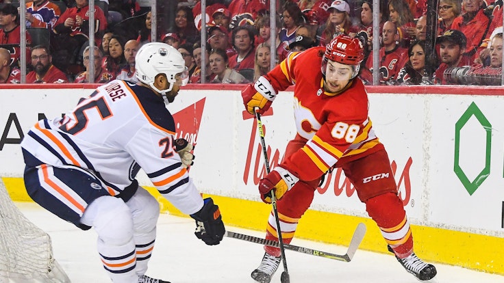 Andrew Mangiapane von den Calgary Flames kämpf mit Darnell Nurse von den Edmonton Oilers auf dem Eis um den Puck.