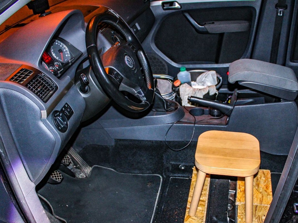 Ein Holzsschemel als Fahrersitz in einem Auto