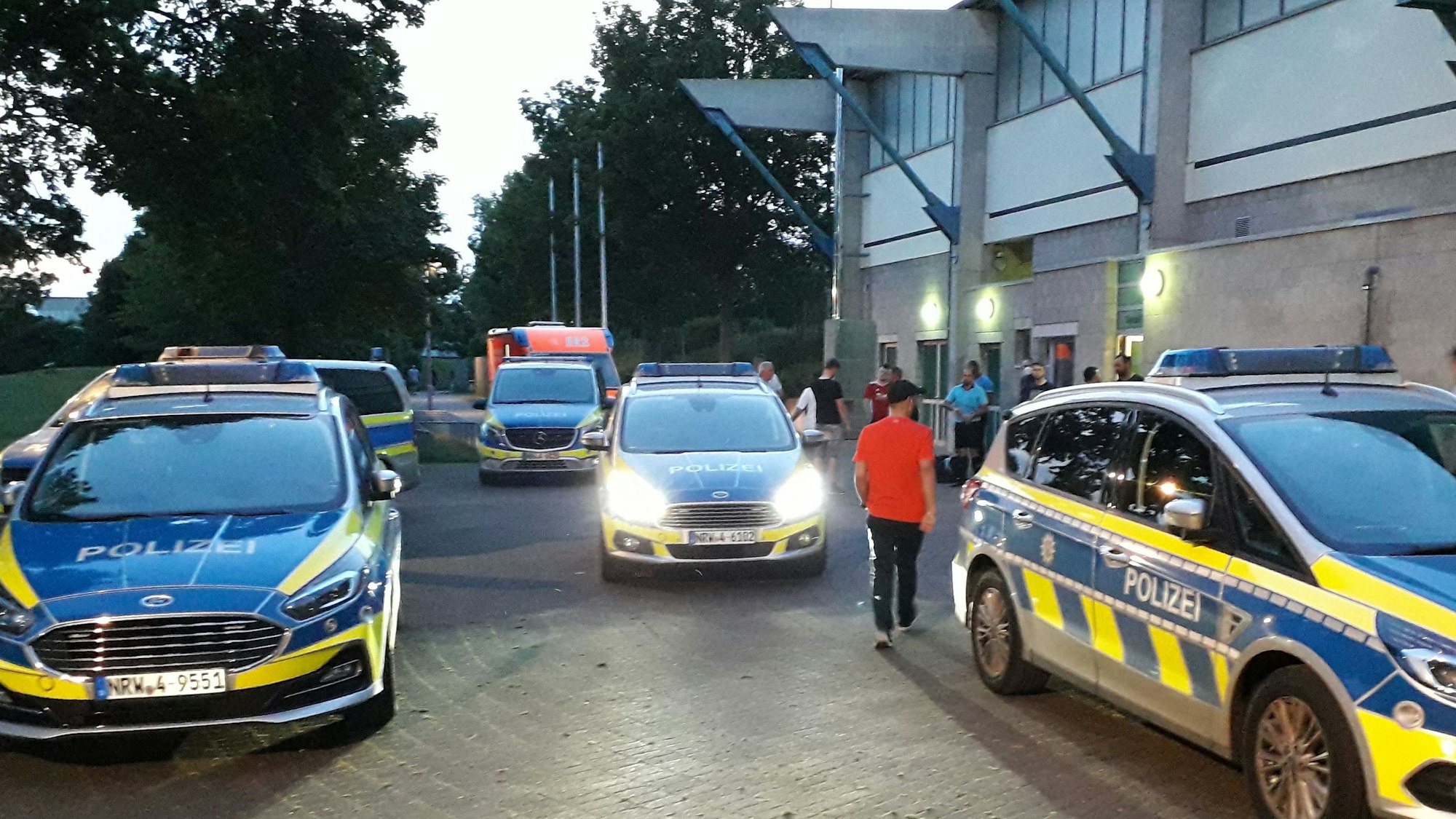 Polizei-Autos stehen an einem Fußballstadion.