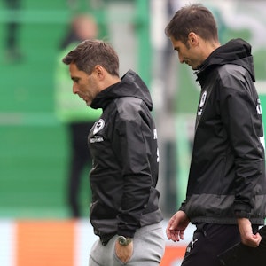 Stefan Leitl (l.) und Co-Trainer André Mijatovic gehen nach dem Bundesliga-Abstieg von Greuther Fürth vom Rasen. Der Start bei Hannover 96 in der 2. Bundesliga könnte sich für das Duo verzögern.