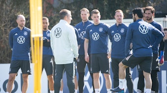 Bundestrainer Hansi Flick spricht mit seinen Spielern, links hört der ehemalige Nationalspieler Benedikt Höwedes, der das Teammanagement bei der Nationalmannschaft verstärkt, mit zu.