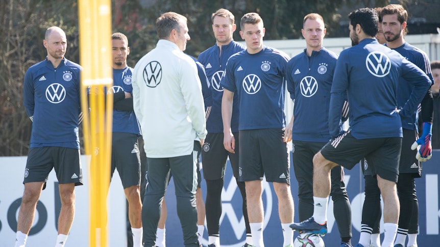 Bundestrainer Hansi Flick spricht mit seinen Spielern, links hört der ehemalige Nationalspieler Benedikt Höwedes, der das Teammanagement bei der Nationalmannschaft verstärkt, mit zu.