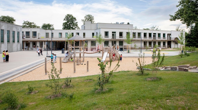 Auf dem Spielplatz vor der Friedrich-List-Schule in Köln-Porz spielen und klettern Kinder.