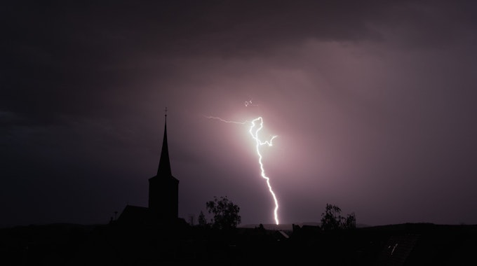 19.05.2022, Bayern, Rattelsdorf: Blitze entladen sich aus einer Gewitterwolke über der Ortschaft.