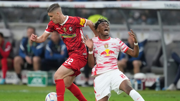 Freiburg's Roland Sallai, left, and Leipzig's Mohamed Simakan fight for the ball during the German Soccer Cup final match between SC Freiburg and RB Leipzig at the Olympic Stadium in Berlin, Germany, Saturday, May 21, 2022. (AP Photo/Michael Sohn)